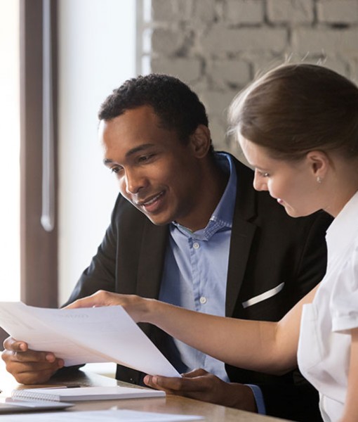 Two people discussing a piece of paper