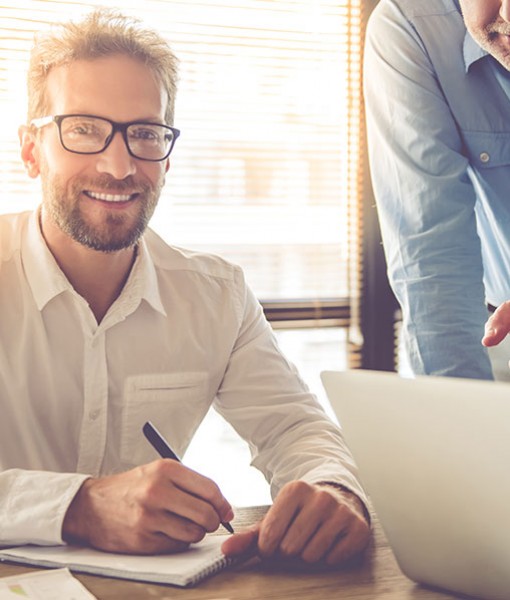 Man smiling while signing paperwork