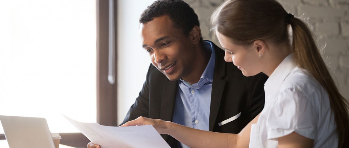 Two people discussing a piece of paper